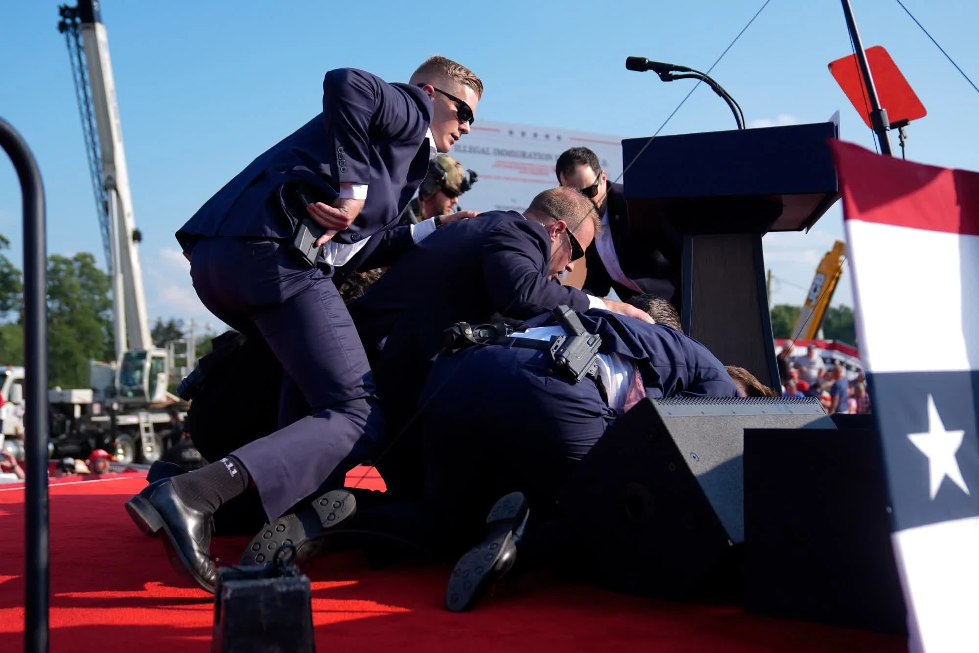 Photo shows Trump being pushed down to the floor by his bodyguards.